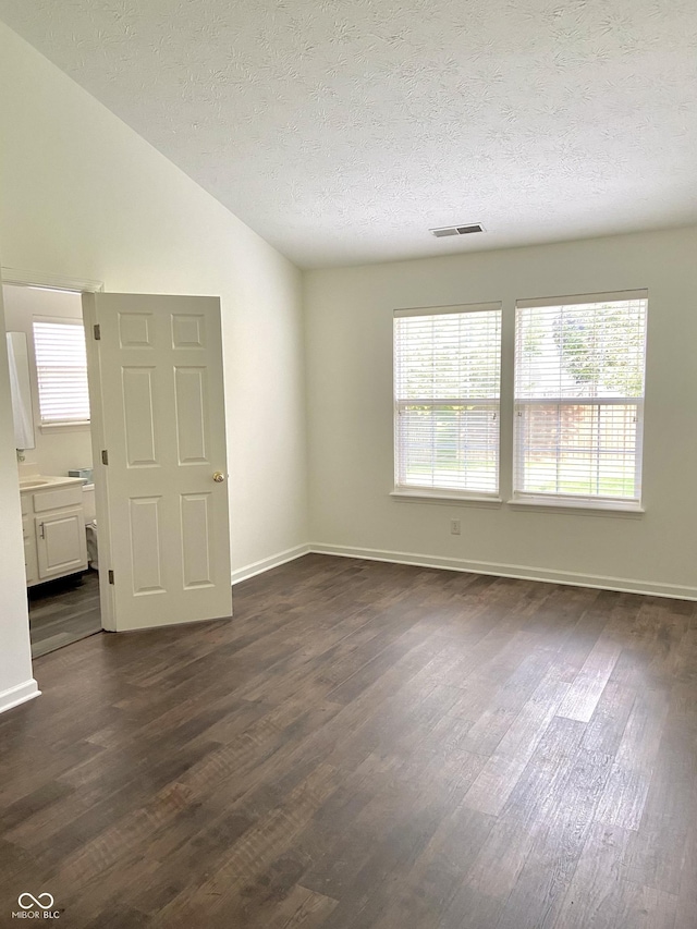 10477 Silver Ridge Cir, Fishers, IN 46038 - spare room with dark wood-style floors, healthy amount of natural light, vaulted ceiling, and a textured ceiling
