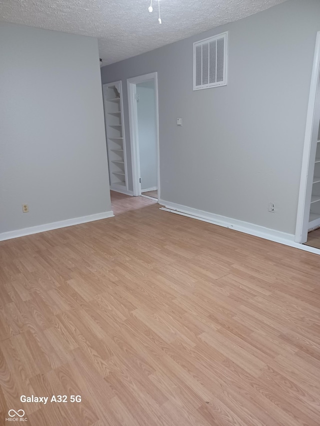 2138 Admiral Dr, Indianapolis, IN 46219 - empty room featuring a textured ceiling and light wood-style flooring