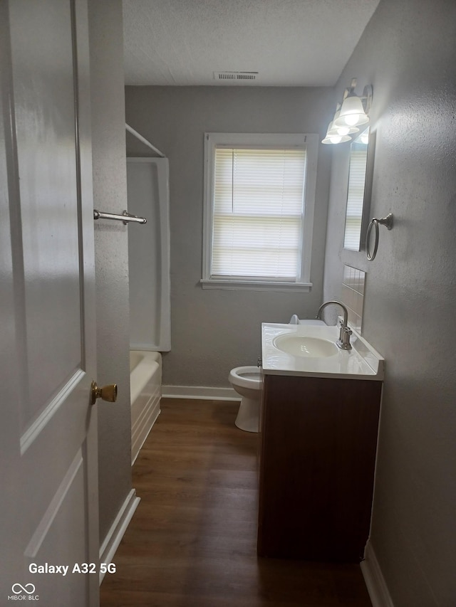 2138 Admiral Dr, Indianapolis, IN 46219 - full bath with vanity, wood finished floors, and washtub / shower combination
