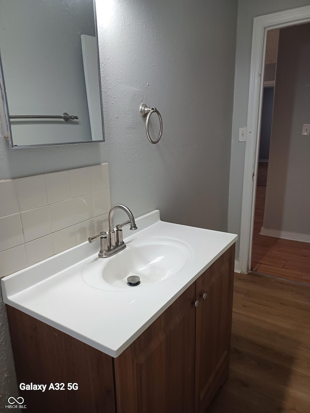2138 Admiral Dr, Indianapolis, IN 46219 - bathroom featuring wood finished floors, vanity, and decorative backsplash
