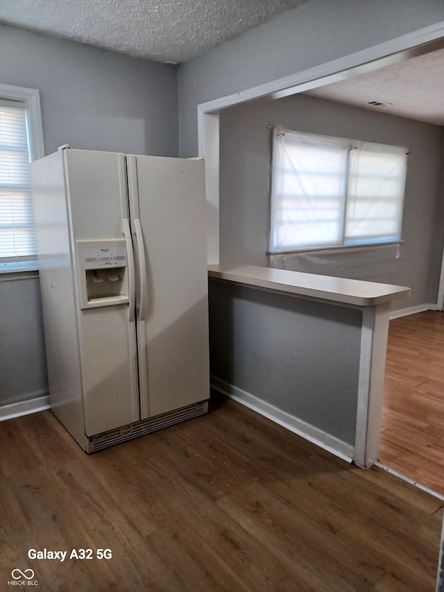 2138 Admiral Dr, Indianapolis, IN 46219 - kitchen featuring white refrigerator with ice dispenser, wood finished floors, plenty of natural light, and a textured ceiling