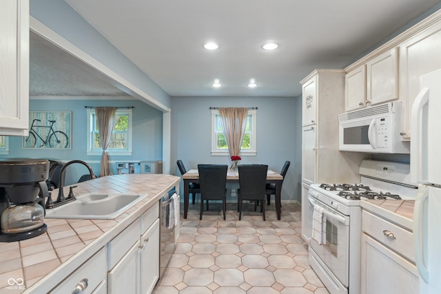 1302 N Furman Ave, Indianapolis, IN 46214 - kitchen with tile counters, white appliances, recessed lighting, light flooring, and plenty of natural light