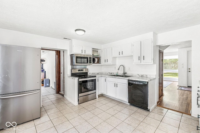 777 Sycamore St, Westfield, IN 46074 - kitchen with stainless steel appliances, light countertops, white cabinetry, a textured ceiling, and light tile patterned flooring