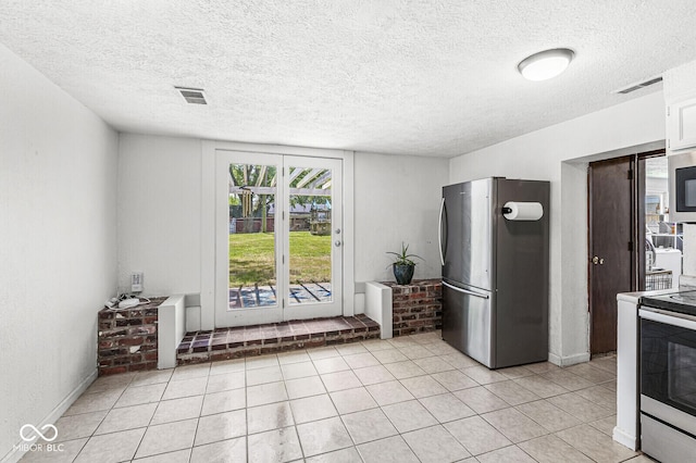 777 Sycamore St, Westfield, IN 46074 - kitchen featuring stainless steel appliances, light tile patterned floors, a textured ceiling, and white cabinetry
