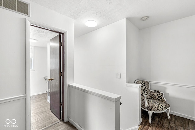 777 Sycamore St, Westfield, IN 46074 - hallway with a textured ceiling, wood finished floors, and an upstairs landing