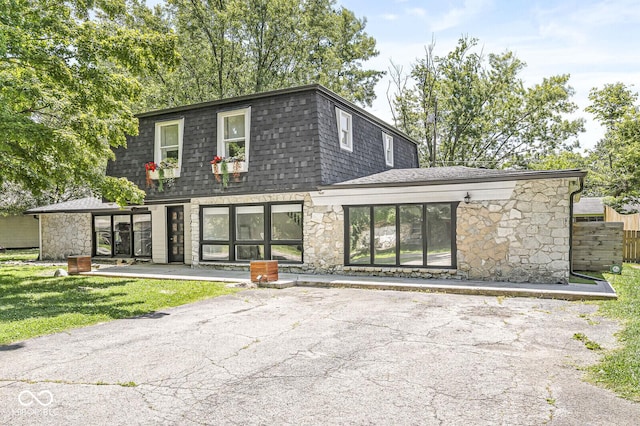 777 Sycamore St, Westfield, IN 46074 - back of house featuring stone siding, roof with shingles, and mansard roof
