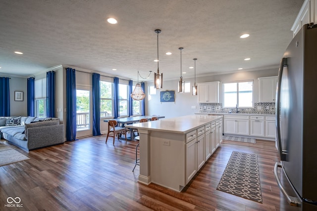 16235 Natures Way, Westfield, IN 46074 - kitchen with freestanding refrigerator, open floor plan, ornamental molding, a center island, and light countertops