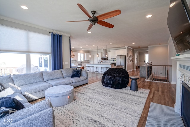 16235 Natures Way, Westfield, IN 46074 - living room featuring ceiling fan, plenty of natural light, wood finished floors, recessed lighting, and ornamental molding