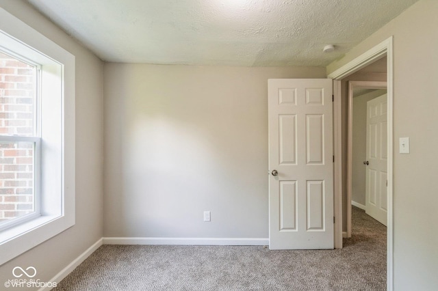 6570 N Private Road 525 E, North Vernon, IN 47265 - unfurnished room featuring plenty of natural light, carpet flooring, a smoke detector, and a textured ceiling