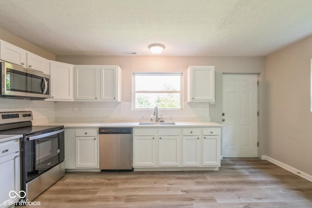 6570 N Private Road 525 E, North Vernon, IN 47265 - kitchen featuring appliances with stainless steel finishes, backsplash, white cabinets, light countertops, and a textured ceiling