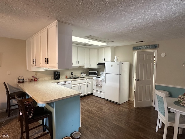 1001 Paradise Ct Unit F, Greenwood, IN 46143 - kitchen featuring white appliances, light countertops, a textured ceiling, a peninsula, and white cabinets
