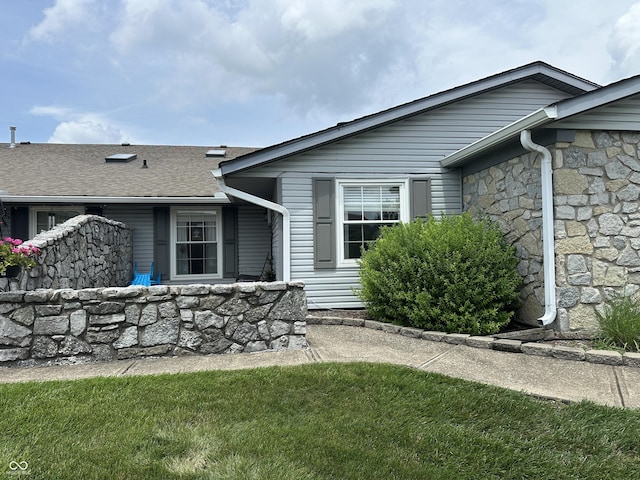 1001 Paradise Ct Unit F, Greenwood, IN 46143 - rear view of property featuring stone siding, a shingled roof, and a lawn