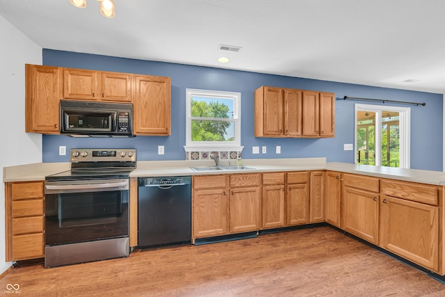 6329 Whitaker Farms Dr, Indianapolis, IN 46237 - kitchen featuring black appliances, light wood-style floors, light countertops, and healthy amount of natural light