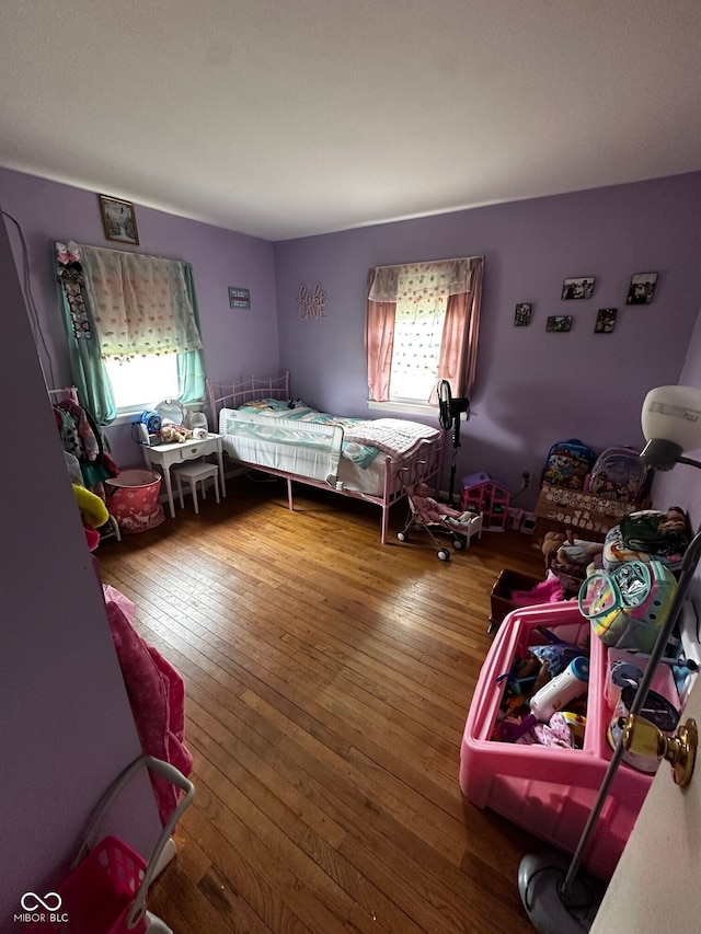 bedroom with multiple windows and wood-type flooring