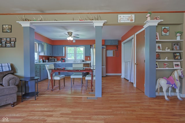 1014 Washington St, Hope, IN 47246 - kitchen featuring appliances with stainless steel finishes, light wood-style floors, a ceiling fan, blue cabinets, and light countertops