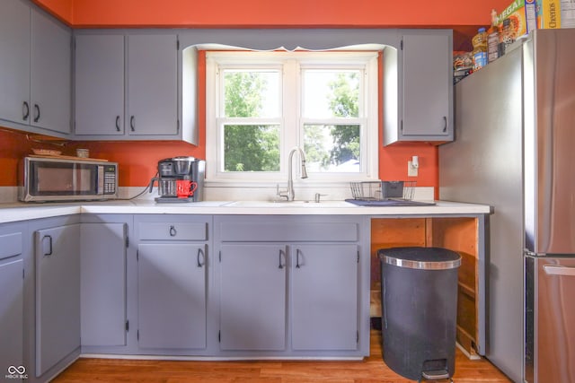 1014 Washington St, Hope, IN 47246 - kitchen with appliances with stainless steel finishes, light countertops, gray cabinets, and light wood finished floors