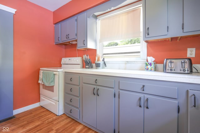 1014 Washington St, Hope, IN 47246 - kitchen featuring white range with electric stovetop, light countertops, and light wood finished floors
