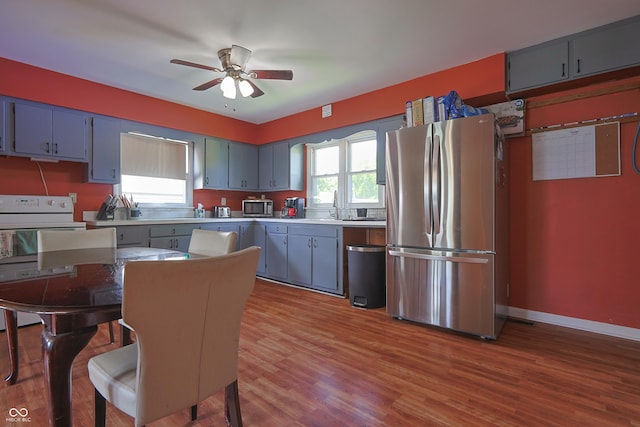 1014 Washington St, Hope, IN 47246 - kitchen featuring appliances with stainless steel finishes, a ceiling fan, wood finished floors, blue cabinetry, and light countertops