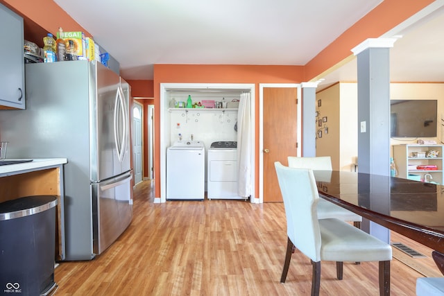 1014 Washington St, Hope, IN 47246 - kitchen featuring freestanding refrigerator, separate washer and dryer, light wood-type flooring, and decorative columns