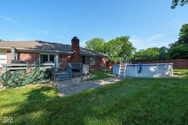 12113 N Rooker Rd, Mooresville, IN 46158 - rear view of house with a deck, a fenced backyard, brick siding, and a chimney