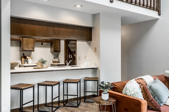 2247 Frisco Pl, Indianapolis, IN 46240 - kitchen featuring a breakfast bar, wood finished floors, light countertops, a peninsula, and recessed lighting