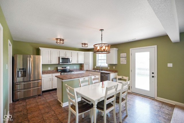 3075 W Crosscreek Dr, Monrovia, IN 46157 - kitchen featuring stainless steel appliances, a center island, white cabinetry, a chandelier, and a textured ceiling