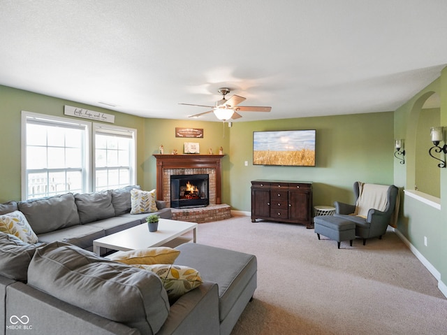 3075 W Crosscreek Dr, Monrovia, IN 46157 - living room with a fireplace, carpet flooring, a ceiling fan, and arched walkways