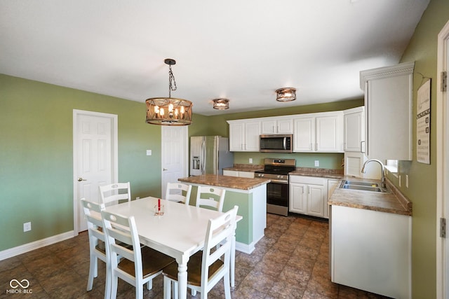 3075 W Crosscreek Dr, Monrovia, IN 46157 - kitchen with appliances with stainless steel finishes, a kitchen island, white cabinetry, and a chandelier