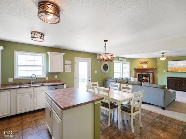 3075 W Crosscreek Dr, Monrovia, IN 46157 - kitchen featuring dark countertops, a fireplace, white cabinetry, a textured ceiling, and a center island
