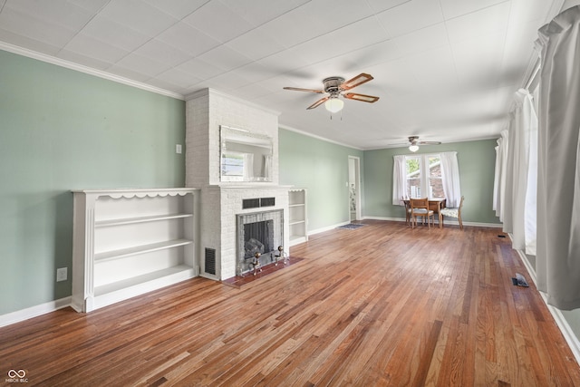 705 N Davidson St, Greensburg, IN 47240 - unfurnished living room featuring ceiling fan, hardwood / wood-style floors, a brick fireplace, and crown molding