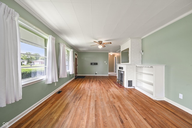 705 N Davidson St, Greensburg, IN 47240 - unfurnished living room with light wood-style flooring, ornamental molding, a fireplace, and a ceiling fan