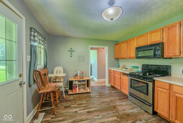 1905 W Brownstown Rd, North Vernon, IN 47265 - kitchen with black microwave, stainless steel electric stove, a textured ceiling, light countertops, and wood finished floors