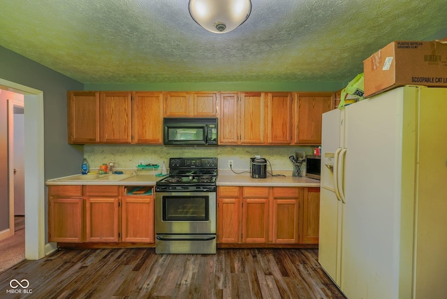 1905 W Brownstown Rd, North Vernon, IN 47265 - kitchen featuring stainless steel appliances, light countertops, dark wood-type flooring, a textured ceiling, and tasteful backsplash