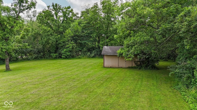 1905 W Brownstown Rd, North Vernon, IN 47265 - view of green lawn featuring a shed and a wooded view