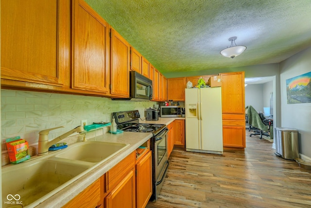 1905 W Brownstown Rd, North Vernon, IN 47265 - kitchen featuring appliances with stainless steel finishes, wood finished floors, light countertops, decorative backsplash, and brown cabinetry