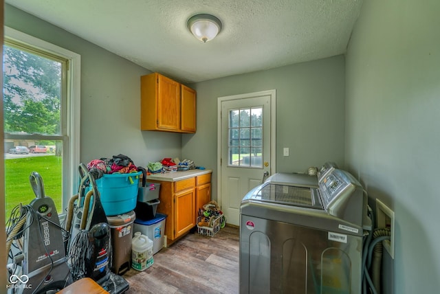 1905 W Brownstown Rd, North Vernon, IN 47265 - laundry area featuring cabinet space, washing machine and dryer, wood finished floors, and a textured ceiling