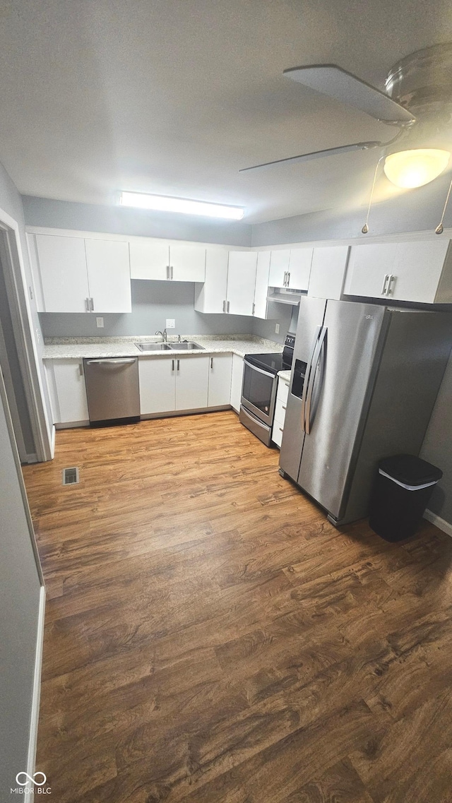 4614 Runyon Lake Dr W, Greenwood, IN 46143 - kitchen with stainless steel appliances, dark wood finished floors, white cabinetry, and light countertops