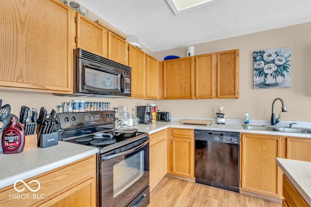 2309 Westmere Dr, Plainfield, IN 46168 - kitchen with black appliances, light countertops, a textured ceiling, and light wood-type flooring