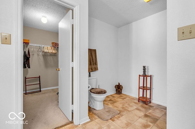 2309 Westmere Dr, Plainfield, IN 46168 - bathroom with a textured ceiling, a spacious closet, and tile patterned floors