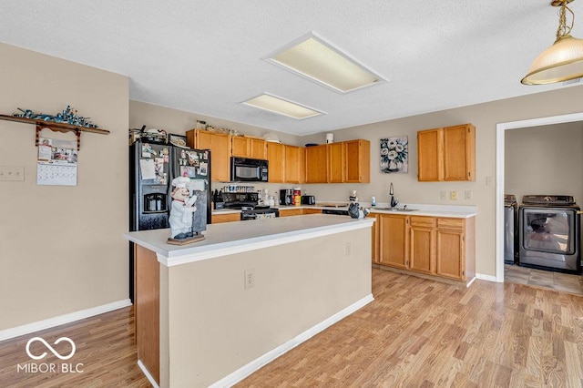 2309 Westmere Dr, Plainfield, IN 46168 - kitchen with black appliances, independent washer and dryer, light countertops, light wood-style floors, and a textured ceiling