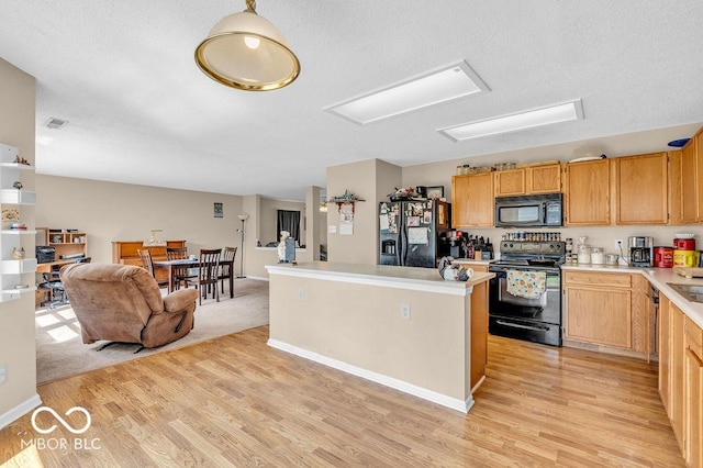 2309 Westmere Dr, Plainfield, IN 46168 - kitchen featuring black appliances, light wood finished floors, light countertops, a kitchen island, and a textured ceiling
