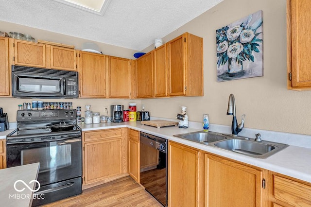 2309 Westmere Dr, Plainfield, IN 46168 - kitchen with black appliances, light countertops, a textured ceiling, and light wood finished floors