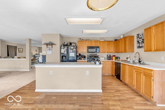2309 Westmere Dr, Plainfield, IN 46168 - kitchen featuring black appliances, a kitchen island, light wood-style floors, light countertops, and open floor plan