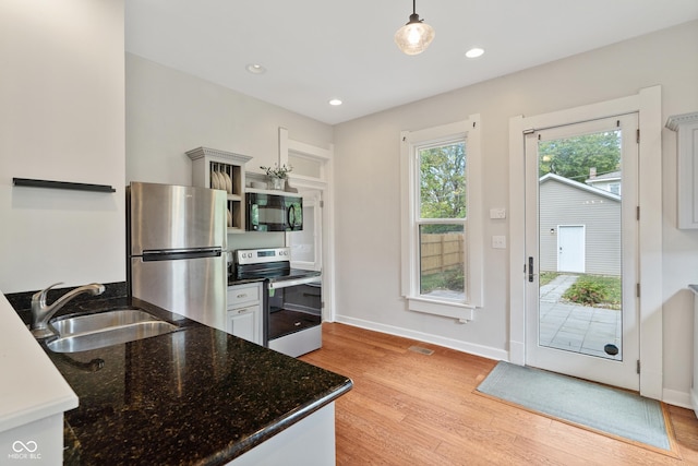 2026 E 10th St, Indianapolis, IN 46201 - kitchen featuring stainless steel appliances, light wood-type flooring, open shelves, pendant lighting, and dark stone counters