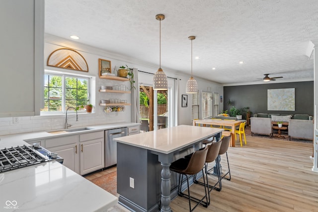 8754 Lily Ct, Zionsville, IN 46077 - kitchen with dishwasher, a ceiling fan, a center island, decorative backsplash, and light wood finished floors