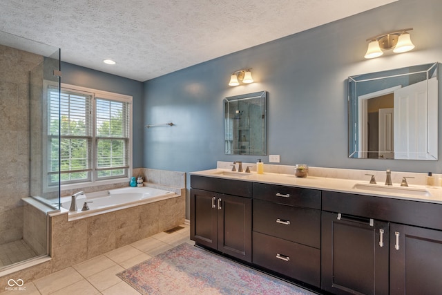 8754 Lily Ct, Zionsville, IN 46077 - full bathroom featuring double vanity, tile patterned floors, a garden tub, tiled shower, and a textured ceiling