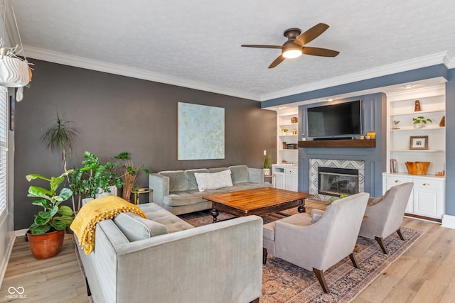 8754 Lily Ct, Zionsville, IN 46077 - living room with a large fireplace, a ceiling fan, light wood-type flooring, and crown molding