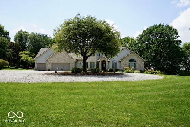 5586 S 200 E, Franklin, IN 46131 - view of front of home featuring a garage, a front yard, stone siding, and gravel driveway