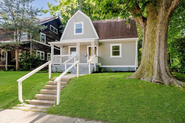 3709 Central Ave, Indianapolis, IN 46205 - colonial inspired home with covered porch, a shingled roof, a front yard, and a gambrel roof