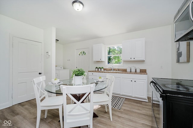 3709 Central Ave, Indianapolis, IN 46205 - dining area with washing machine and dryer and light wood-style flooring